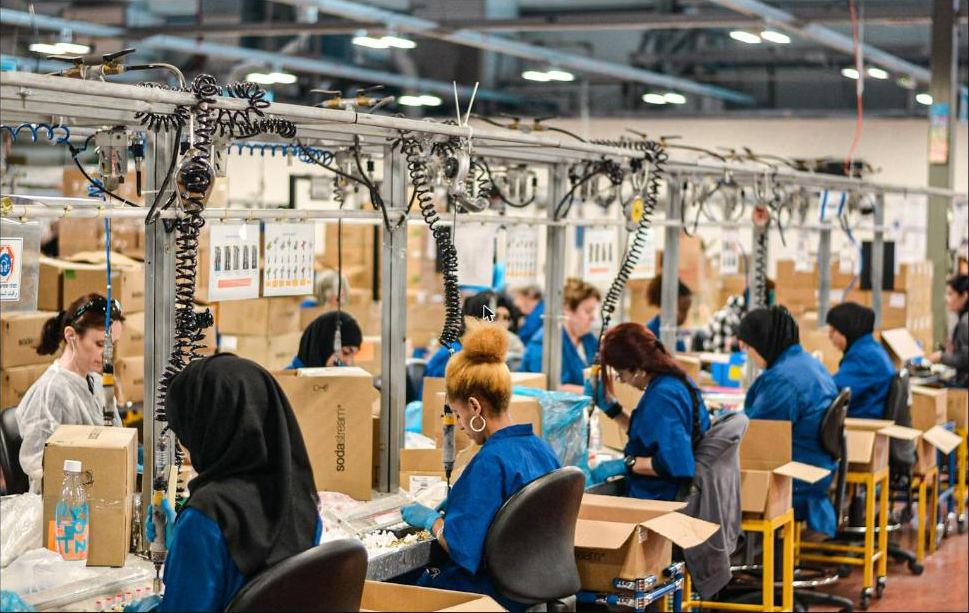 Assembly line workers in blue uniforms